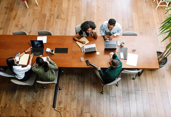 Professionals collaborating around a table during a meeting in a modern office.