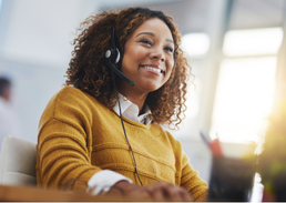 Customer service professional wearing a headset and working at a computer.