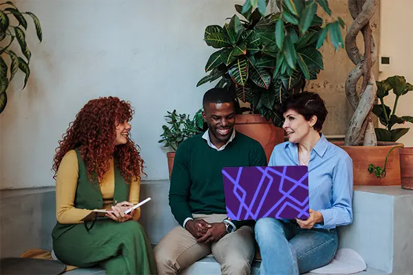 Three people collaborating with a laptop.