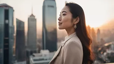 Person standing outdoors with a city skyline in the background.