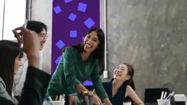 team members collaborating around a desk during an office meeting.