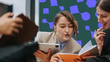 Professionals reviewing notes and a tablet during a collaborative meeting.