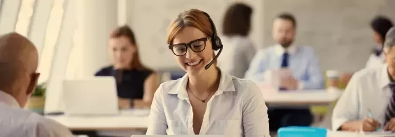 Professional using a headset while working at a desk in a modern office.