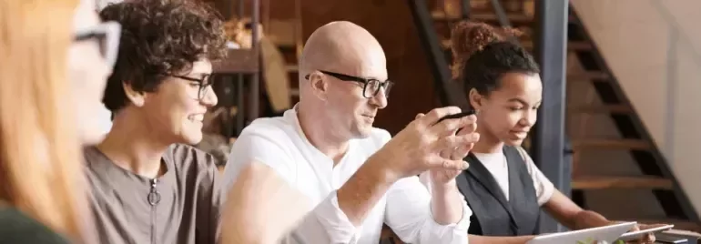 Professionals collaborating together around a table in a modern workplace setting.