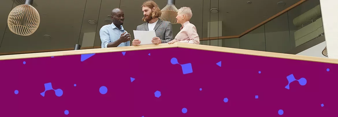 Professionals reviewing documents together from a balcony in a modern office.
