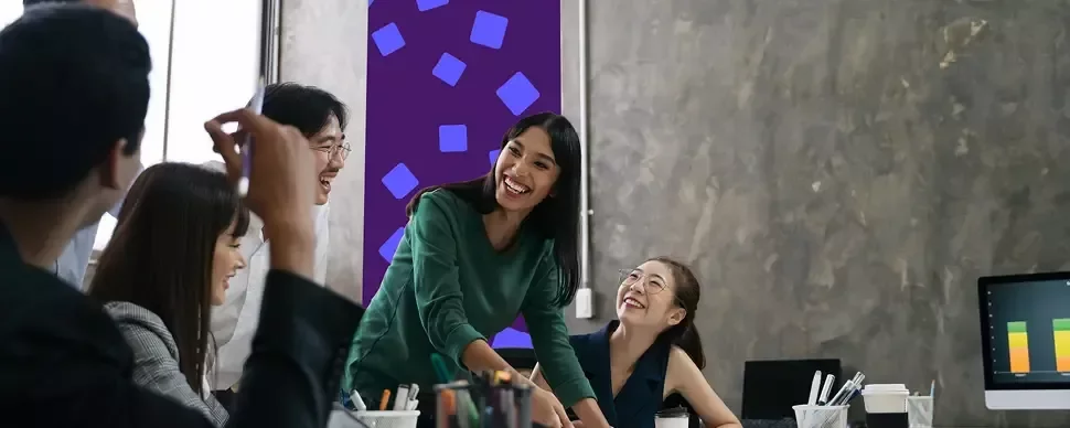 team members collaborating around a desk during an office meeting.